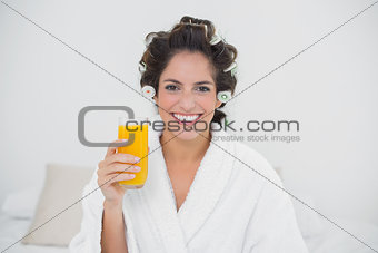 Cheerful natural brunette holding glass of orange juice