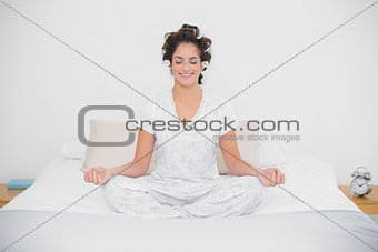 Smiling natural brunette sitting in lotus pose