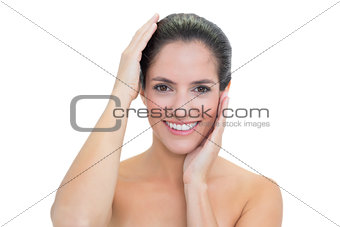 Smiling bare brunette touching her head