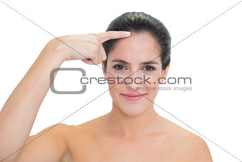 Content bare brunette pointing at forehead