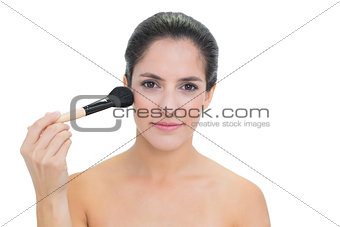 Content bare brunette holding powder brush