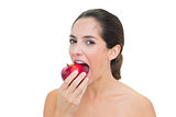 Smiling bare brunette eating red apple