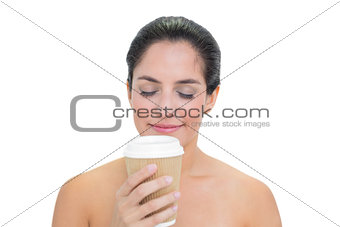 Smiling bare brunette smelling disposable cup