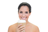 Smiling bare brunette holding disposable cup