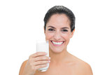 Smiling bare brunette holding glass of milk
