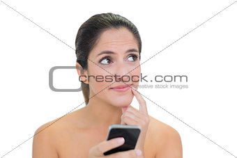Pensive bare brunette using smartphone