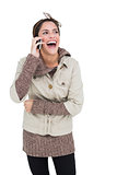 Laughing cute brunette in winter fashion phoning