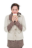 Content cute brunette in winter fashion holding disposable cup