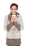 Cheerful cute brunette in winter fashion holding disposable cup