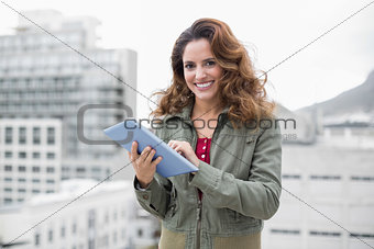 Cheerful gorgeous brunette in winter fashion using tablet