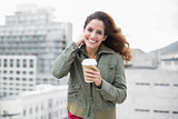 Happy gorgeous brunette in winter fashion holding disposable cup