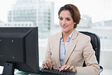 Smiling businesswoman sitting in front of computer