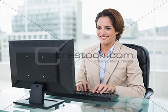 Cheerful businesswoman sitting in front of computer