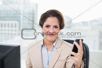 Angry businesswoman holding smartphone