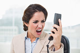 Raging businesswoman shouting into phone