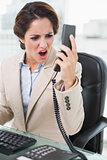 Frustrated businesswoman shouting at phone