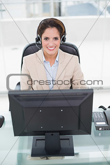 Happy businesswoman sitting in front of computer