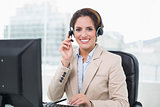 Smiling businesswoman touching headset