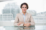 Relaxed businesswoman looking at camera at her desk