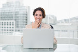 Surprised businesswoman using laptop at her desk