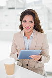 Happy businesswoman using digital tablet at her desk