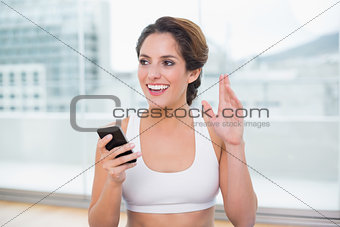 Sporty smiling brunette waving
