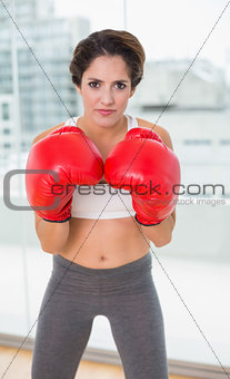 Serious brunette boxing and looking at camera