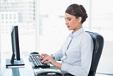 Peaceful classy brown haired businesswoman typing on a computer