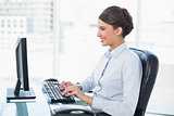 Cheerful classy brown haired businesswoman using a computer