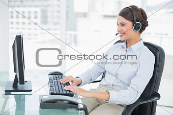 Cheerful classy brown haired operator using her computer