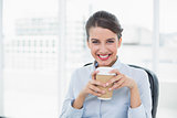 Delighted classy brown haired businesswoman enjoying coffee
