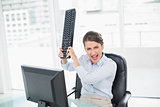 Annoyed classy brown haired businesswoman throwing her keyboard on her computer