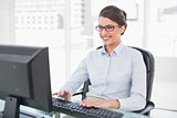 Pleased classy brown haired businesswoman using a computer