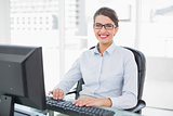 Cheerful classy brown haired businesswoman typing on a computer
