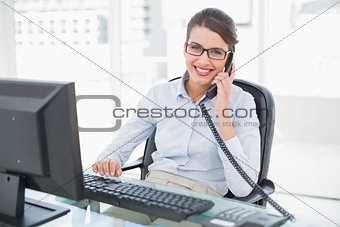 Content classy brown haired businesswoman answering the telephone