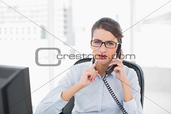 Troubled classy brown haired businesswoman answering the telephone