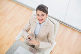 Delighted smart brown haired businesswoman using a mobile phone