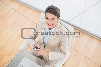 Delighted smart brown haired businesswoman using a mobile phone