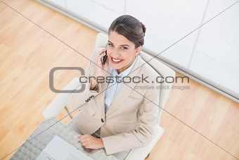 Amused smart brown haired businesswoman making a phone call
