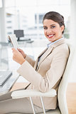 Attractive smart brown haired businesswoman reading a newspaper