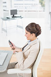 Charming smart brown haired businesswoman using a mobile phone