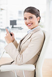 Happy smart brown haired businesswoman using a mobile phone