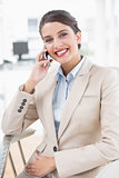 Cheerful smart brown haired businesswoman making a phone call