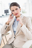 Thoughtful smart brown haired businesswoman making a phone call