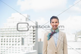 Happy smart brown haired businesswoman looking at camera