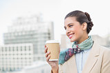 Happy smart brown haired businesswoman holding a cup of coffee