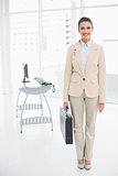 Pleased smart brown haired businesswoman carrying a briefcase