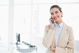 Smiling smart brown haired businesswoman making a phone call