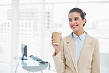 Cheerful smart brown haired businesswoman holding a cup of coffee