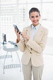 Pretty smart brown haired businesswoman using a calculator
